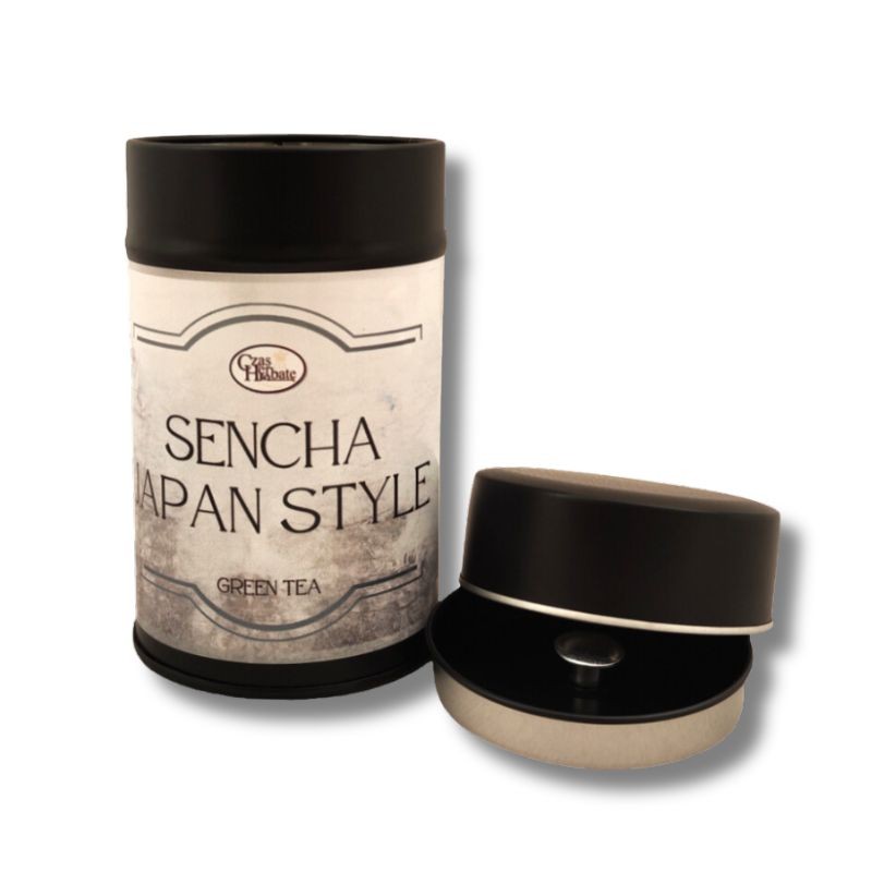 Metalowa puszka herbaty zielonej Sencha Japan Style na tle białym, obok otwarta pokrywka z sitkiem.
